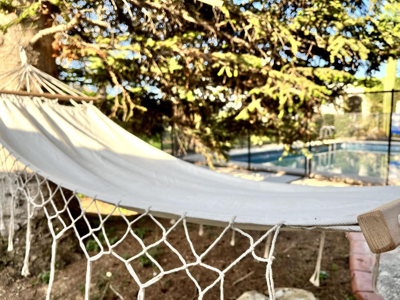 Hamaca en el jardín de Le Chic Garage, con la piscina al fondo